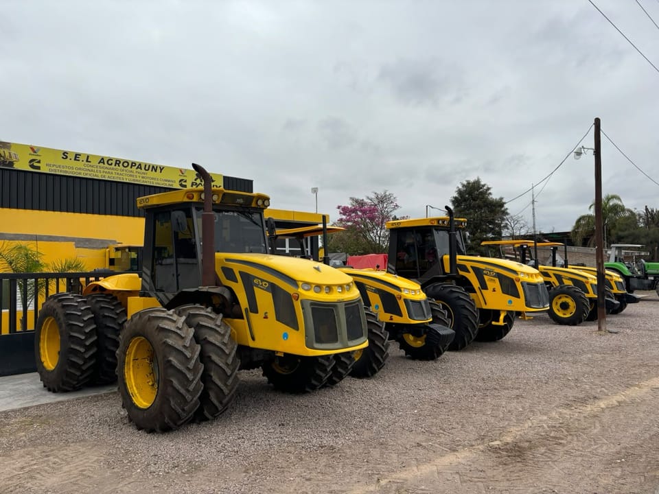Fila de tractores Pauny EVO 0km frente al cartel de Sel Agropauny, La Banda